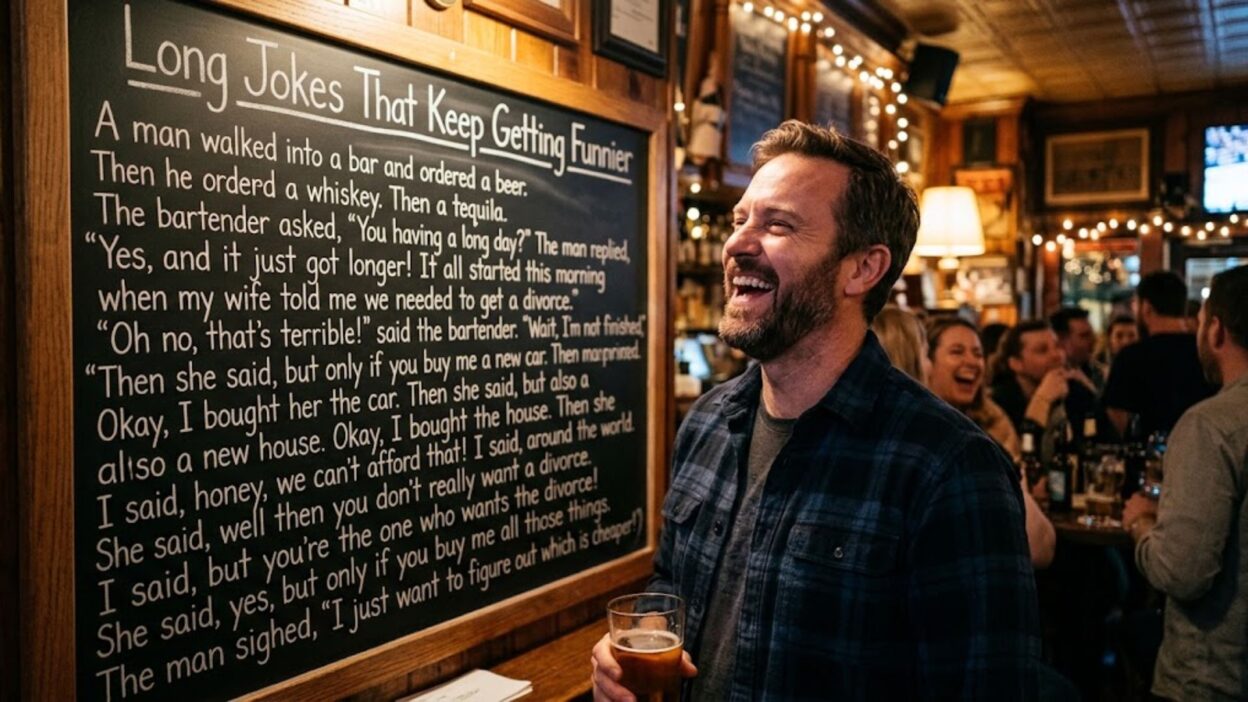 Man laughing next to a large chalkboard joke while holding a beer in a crowded pub